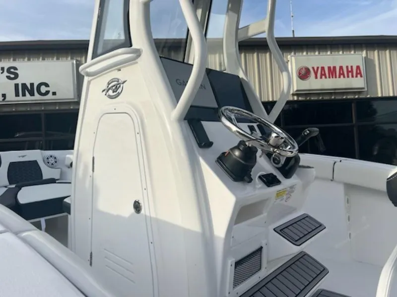 Slide: The Image of 2024 Tidewater 232 LXF boat console with steering wheel, displayed at a dealership. - 6