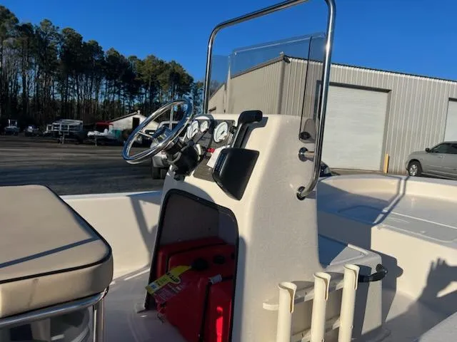 Slide: The Image of 2025 Carolina Skiff E18 CC boat console with steering wheel and gauges, parked outdoors. - 6