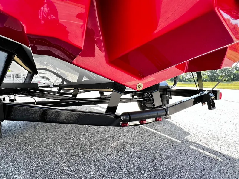 Slide: The Image of 2023 Four Winns H1 OB boat trailer with red hull on pavement. - 29