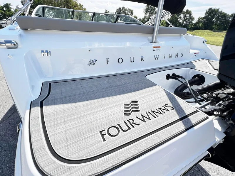 Slide: The Image of 2023 Four Winns H1 OB boat rear deck with logo and outboard motor. - 30