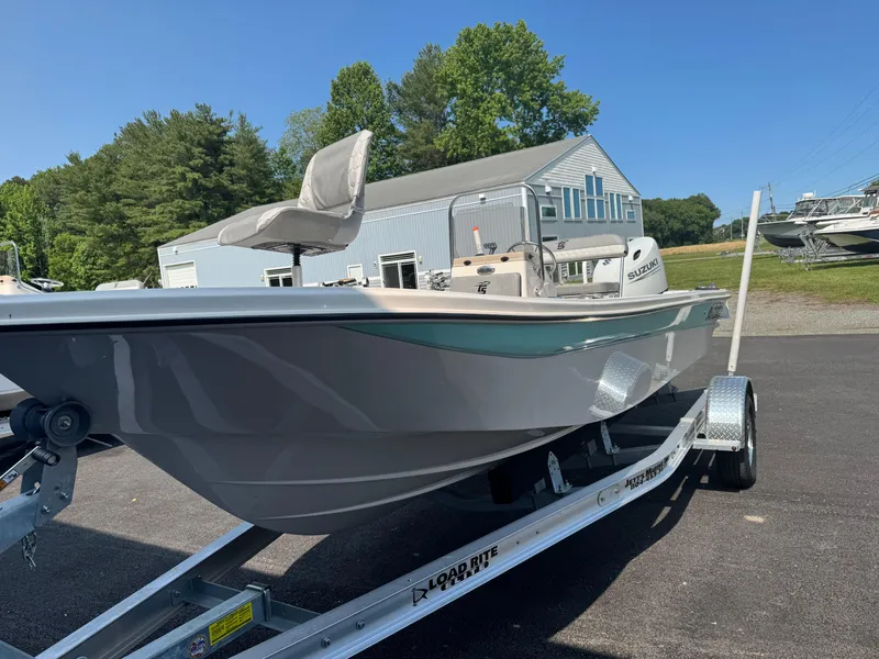 Slide: The Image of 2025 Carolina Skiff 192 JLS boat on trailer, parked outdoors near a building. - 3