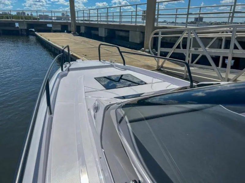 Slide: The Image of 2024 Axopar 25 Cross Top boat docked at marina under clear sky. - 12