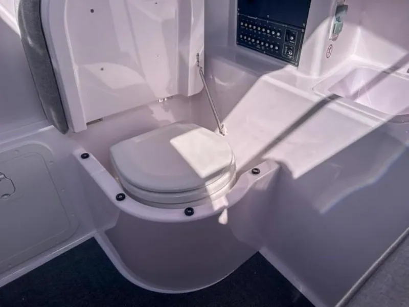 Slide: The Image of 2024 Axopar 25 Cross Top boat interior with compact marine toilet. - 18