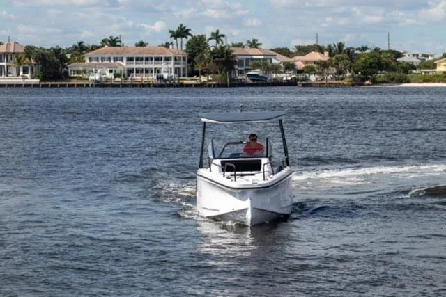 Slide: The Image of 2024 Axopar 25 Cross Top boat cruising on a scenic waterway. - 8