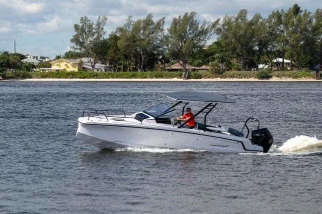 Slide: The Image of 2024 Axopar 25 Cross Top boat cruising on a calm river. - 9