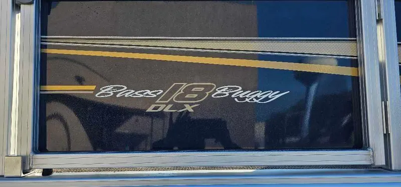 Slide: The Image of 2024 Sun Tracker Bass Buggy 18 DLX logo on boat exterior. - 2