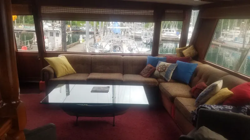 Slide: The Image of Interior of 1974 Stephens 68 Motor Yacht with cozy seating and marina view. - 10