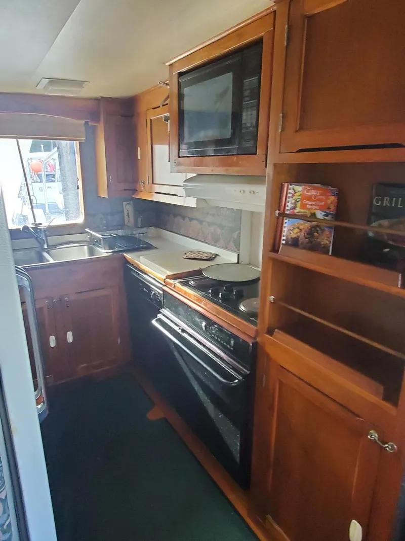 Slide: The Image of 1974 Stephens 68 Motor Yacht kitchen with wooden cabinets and modern appliances. - 13