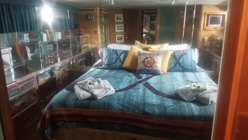 Slide: The Image of Luxurious bedroom on a 1974 Stephens 68 Motor Yacht with nautical-themed bedding. - 14