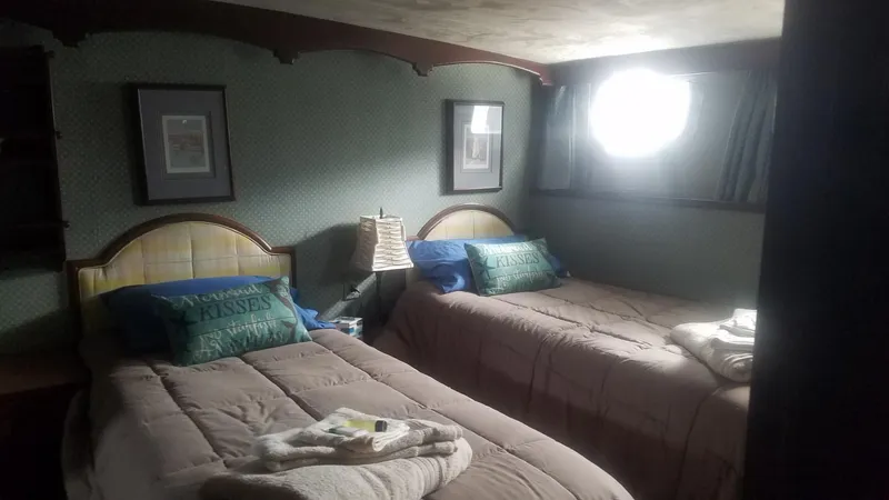 Slide: The Image of Cozy twin bedroom in a 1974 Stephens 68 Motor Yacht with soft lighting. - 15