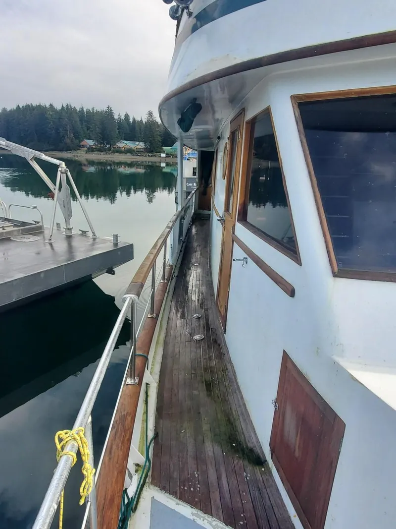 Slide: The Image of 1974 Stephens 68 Motor Yacht docked, showing side deck and cabin windows. - 2