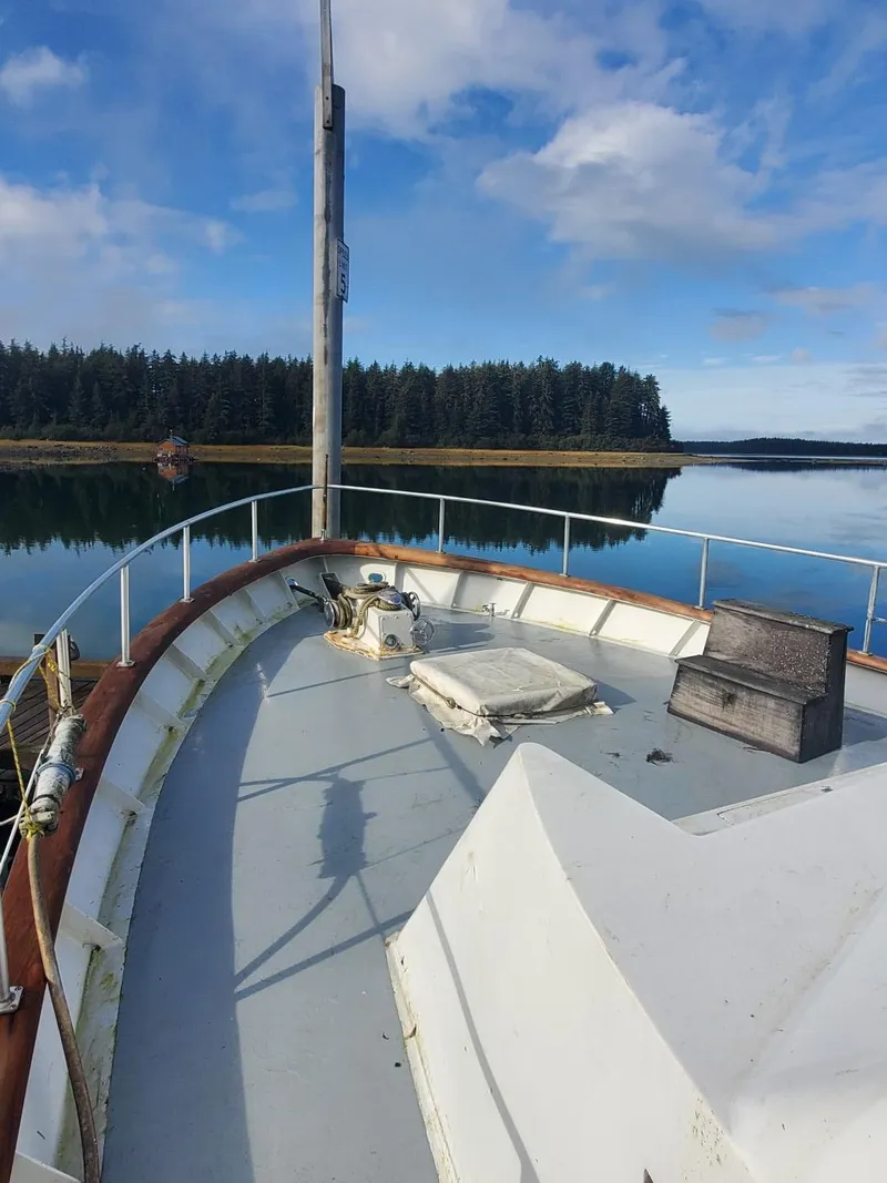 Slide: The Image of 1974 Stephens 68 Motor Yacht on calm water with forested shoreline. - 4