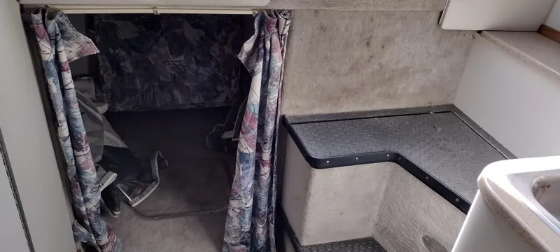Slide: The Image of Interior cabin of a 1997 Crownline 250 CR boat with patterned curtains. - 11