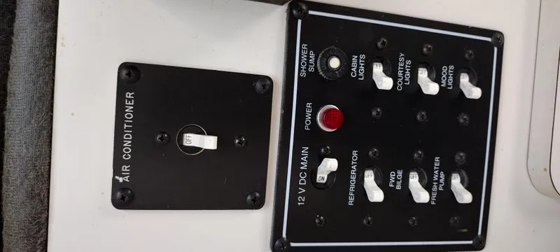 Slide: The Image of Control panel of a 1997 Crownline 250 CR boat with air conditioner and 12V DC main switches. - 14