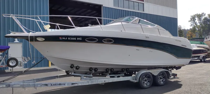 Slide: The Image of 1997 Crownline 250 CR boat on a Load Rite trailer outside a blue warehouse. - 2