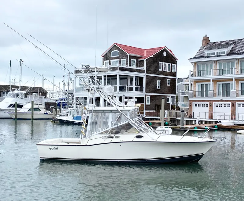 Slide: The Image of 2004 Carolina Classic 28 boat docked in a marina with waterfront homes. - 0