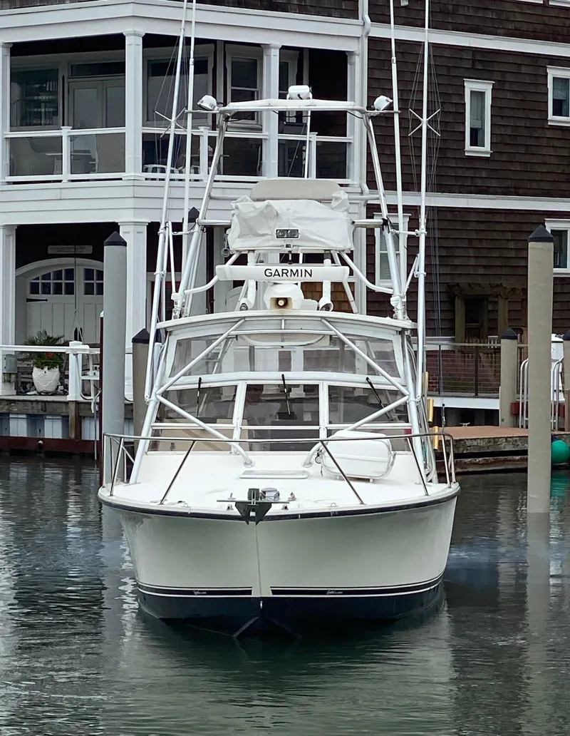 Slide: The Image of 2004 Carolina Classic 28 boat docked near waterfront building. - 1