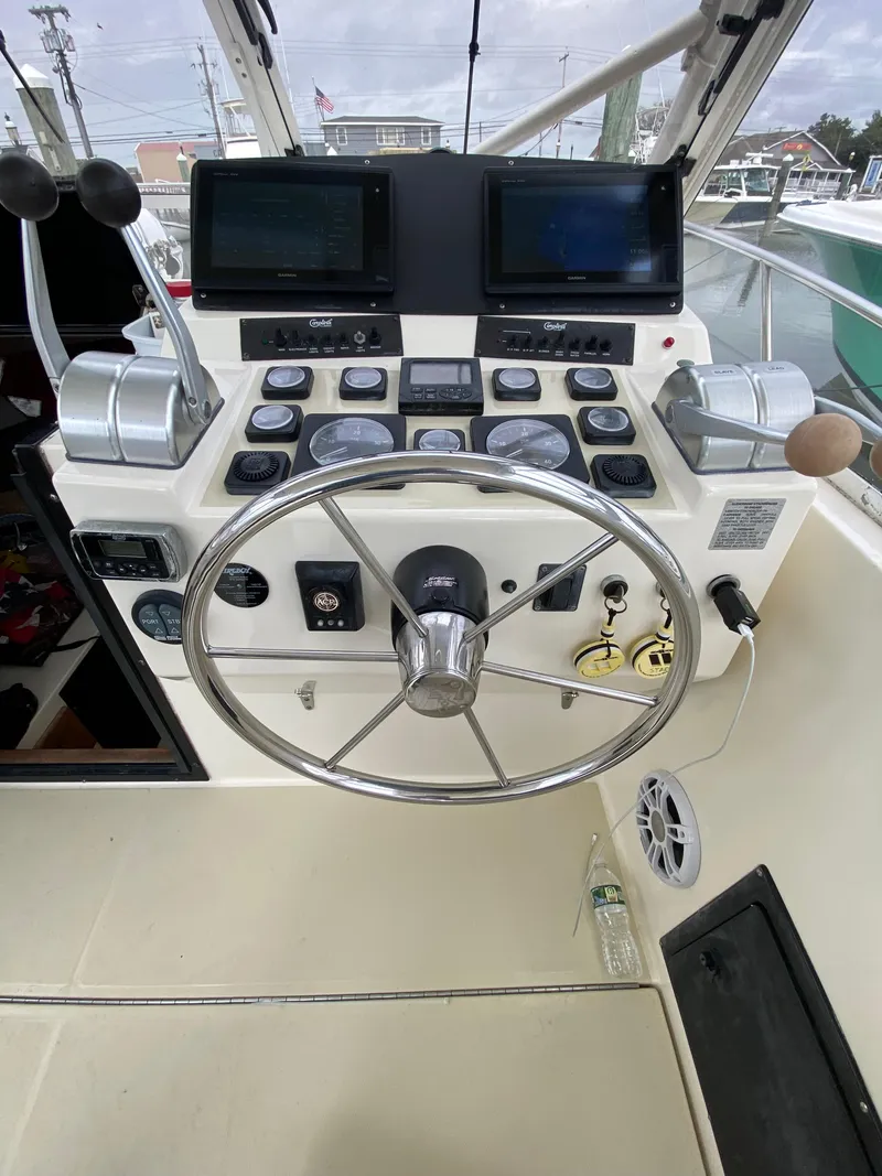 Slide: The Image of Control panel of a 2004 Carolina Classic 28 boat with steering wheel and gauges. - 10