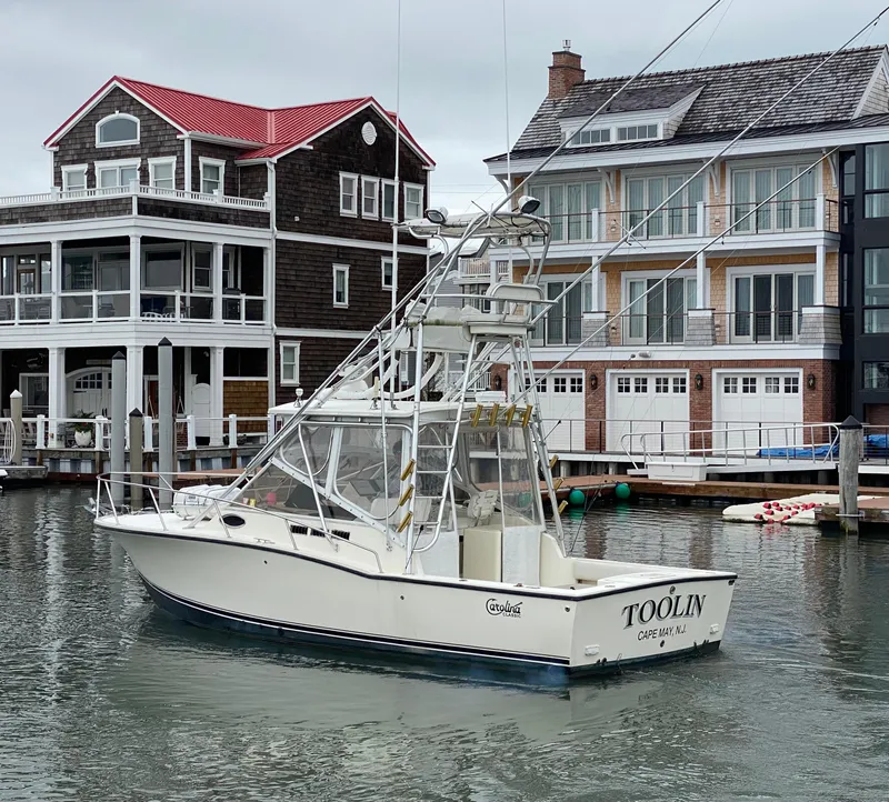 Slide: The Image of 2004 Carolina Classic 28 boat docked near waterfront homes. - 14
