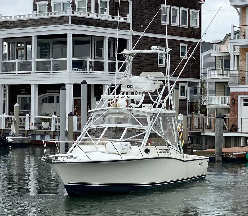 Slide: The Image of 2004 Carolina Classic 28 boat docked near waterfront homes. - 2