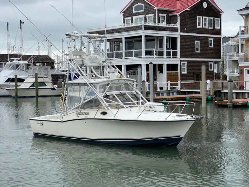 Slide: The Image of 2004 Carolina Classic 28 boat docked near waterfront homes. - 3