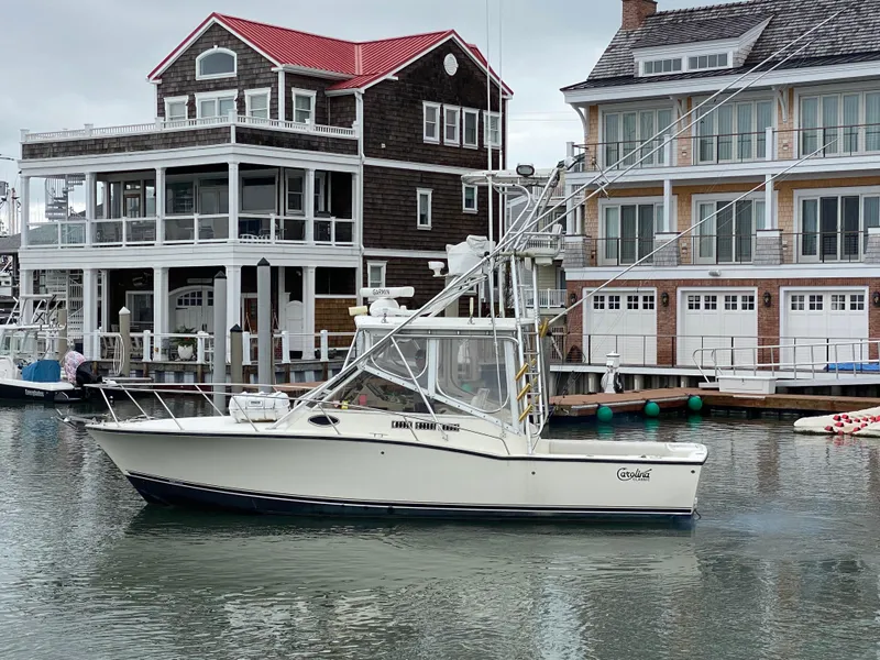Slide: The Image of 2004 Carolina Classic 28 boat docked near waterfront homes. - 4