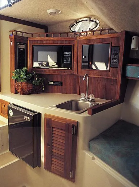 Slide: The Image of Compact kitchen area in a 2004 Carolina Classic 28 boat with microwave, sink, and mini-fridge. - 6