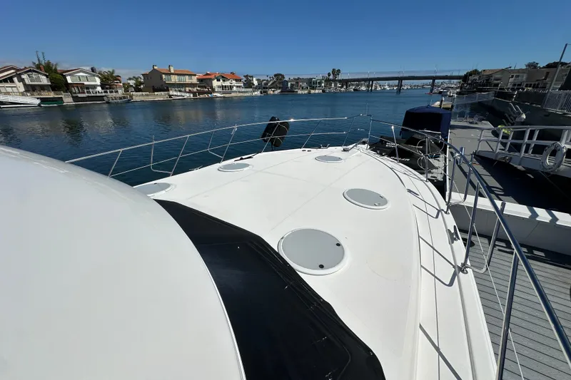 Slide: The Image of 2005 Riviera 47 Open Flybridge yacht docked in a scenic waterfront marina. - 20