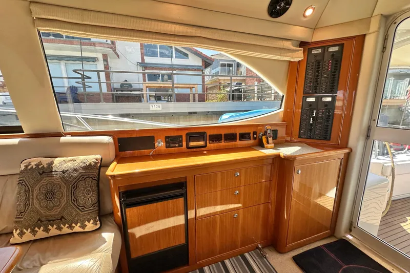 Slide: The Image of Interior of 2005 Riviera 47 Open Flybridge yacht with wooden cabinetry and control panel. - 24