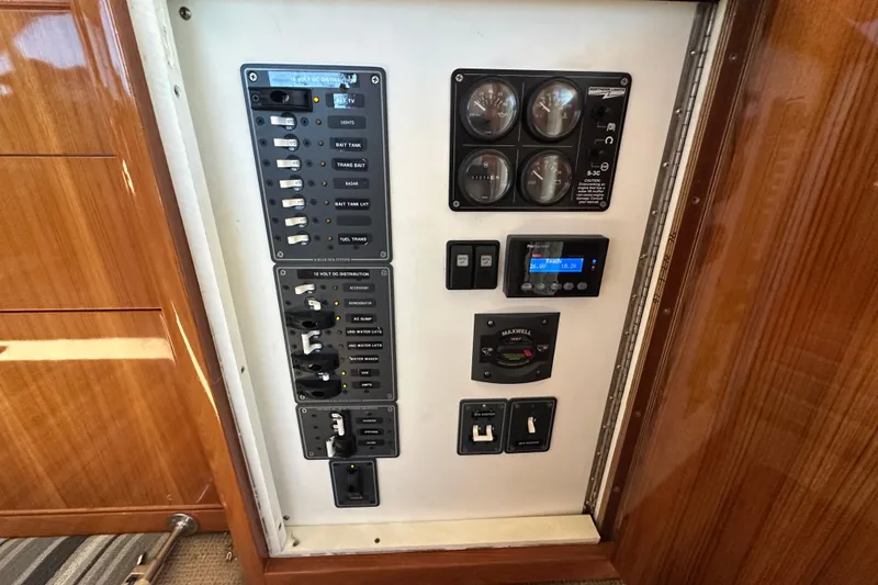 Slide: The Image of Control panel of a 2005 Riviera 47 Open Flybridge yacht, featuring switches and gauges. - 28