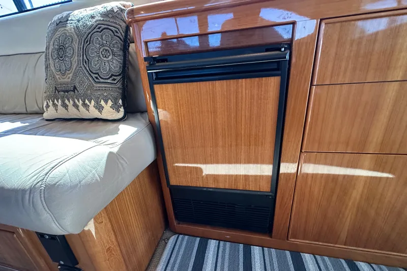 Slide: The Image of Interior of 2005 Riviera 47 Open Flybridge with wood cabinetry and cushioned seating. - 29