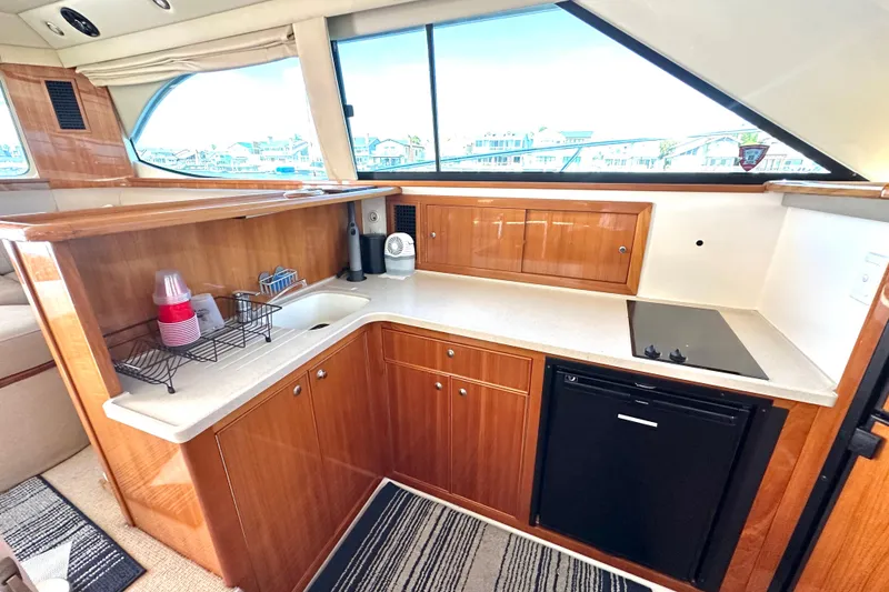 Slide: The Image of Luxurious 2005 Riviera 47 Open Flybridge yacht kitchen with modern amenities and sleek wood cabinetry. - 35