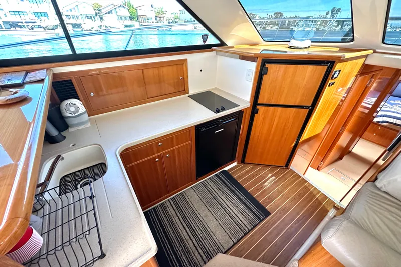 Slide: The Image of Luxurious 2005 Riviera 47 Open Flybridge yacht interior with modern kitchen and wood finishes. - 36