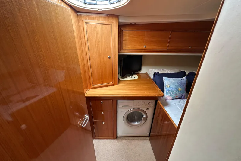 Slide: The Image of 2005 Riviera 47 Open Flybridge cabin with wood cabinetry, washer, and cozy bed. - 39