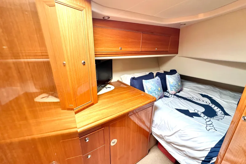 Slide: The Image of Luxurious cabin interior of 2005 Riviera 47 Open Flybridge yacht with wood cabinetry and cozy bedding. - 41