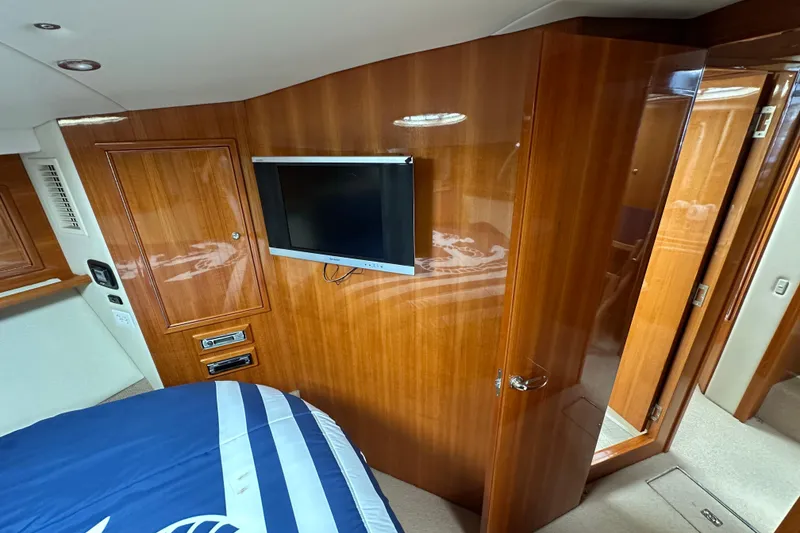 Slide: The Image of Interior of 2005 Riviera 47 Open Flybridge with wood paneling and mounted TV. - 43