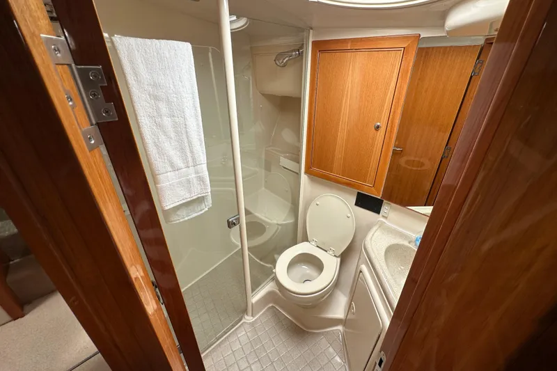 Slide: The Image of Bathroom interior of 2005 Riviera 47 Open Flybridge yacht, featuring shower and wooden cabinetry. - 44