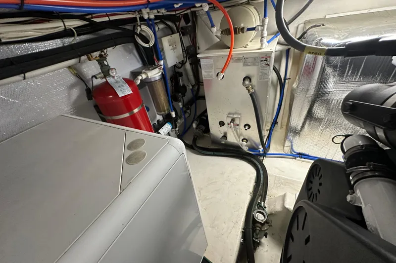 Slide: The Image of Engine room of 2005 Riviera 47 Open Flybridge with equipment and fire extinguisher. - 48