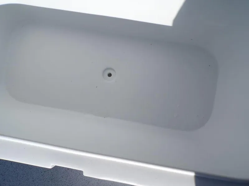 Slide: The Image of Custom 1800 Tunnel 2024 boat storage compartment, white interior, close-up view. - 21