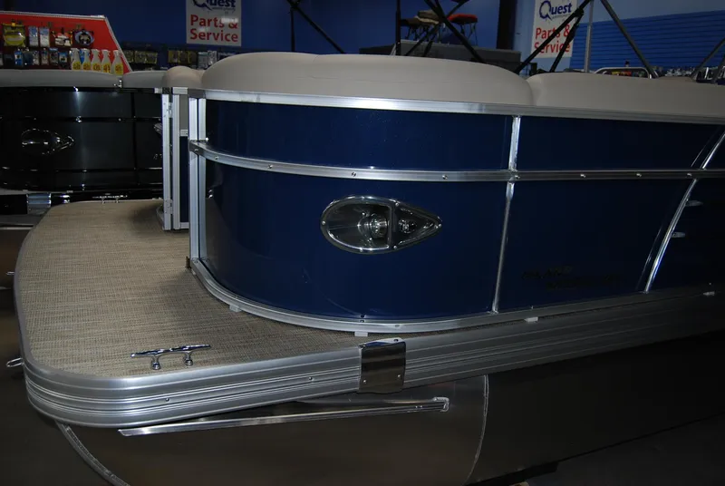 Slide: The Image of 2024 Landau Island Breeze 252 pontoon boat, blue exterior, displayed indoors. - 10