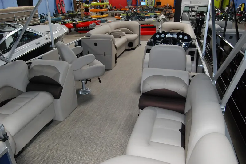 Slide: The Image of 2024 Landau Island Breeze 252 pontoon boat interior with plush seating and modern dashboard. - 2