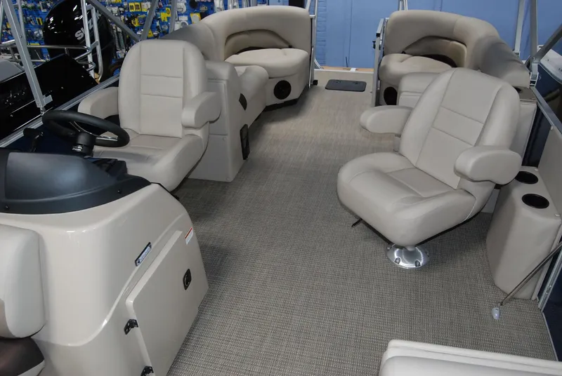 Slide: The Image of 2024 Landau Island Breeze 252 pontoon boat interior with beige seating and carpet. - 6