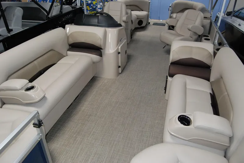 Slide: The Image of 2024 Landau Island Breeze 252 pontoon boat interior with beige seating and cup holders. - 7
