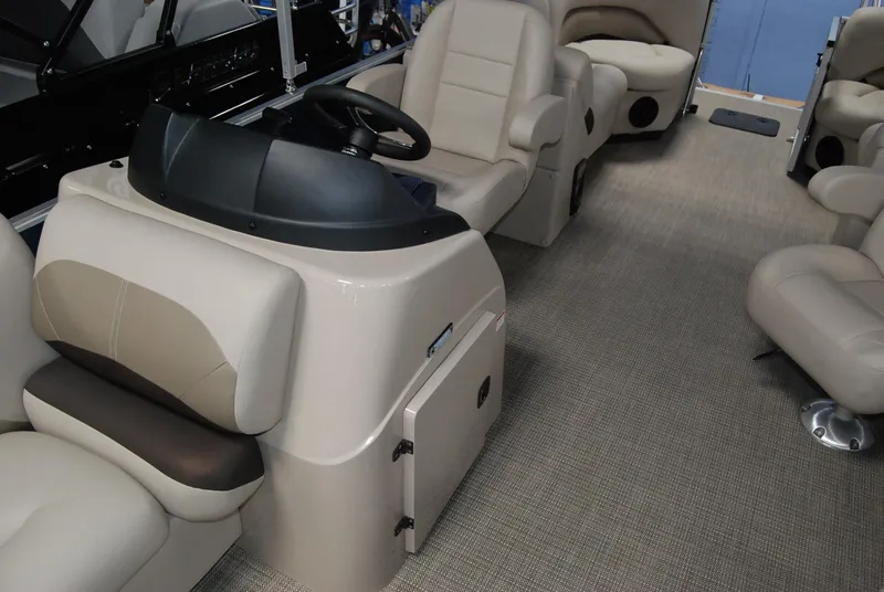 Slide: The Image of 2024 Landau Island Breeze 252 interior with beige seating and steering console. - 9