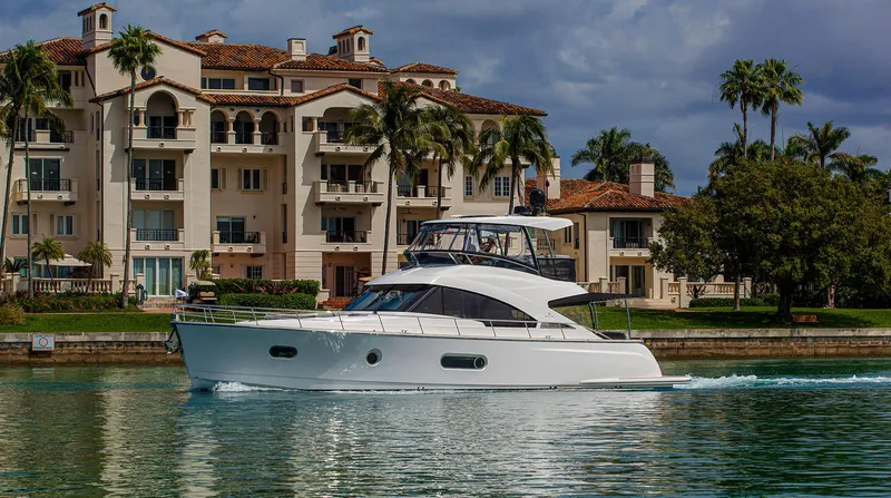 Slide: The Image of 2024 Belize 54 Daybridge yacht cruising near luxury waterfront homes. - 5