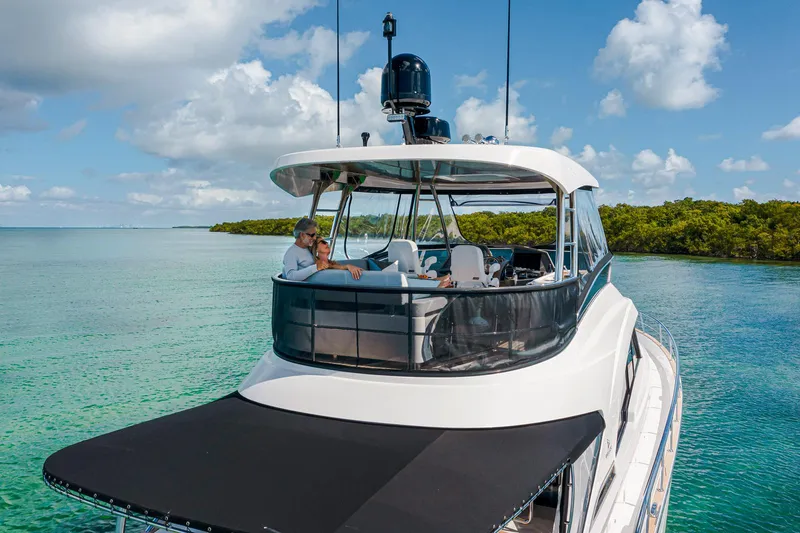 Slide: The Image of 2024 Belize 54 Daybridge yacht cruising in clear waters with passengers relaxing. - 6