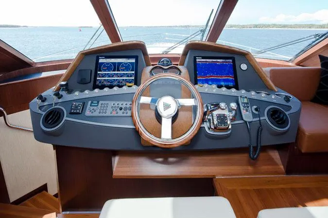 Slide: The Image of 2024 Belize 54 Sedan yacht helm with advanced navigation systems and luxurious wood finish. - 3