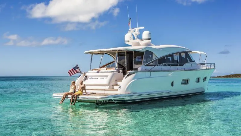 Slide: The Image of 2024 Belize 66 Sedan yacht anchored in clear turquoise waters. - 1