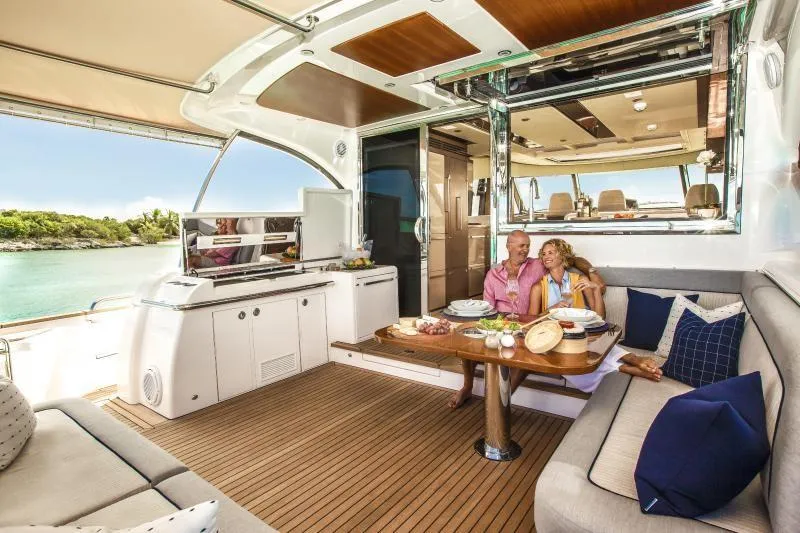 Slide: The Image of Couple relaxing on a 2024 Belize 66 Sedan yacht with a scenic ocean view. - 7