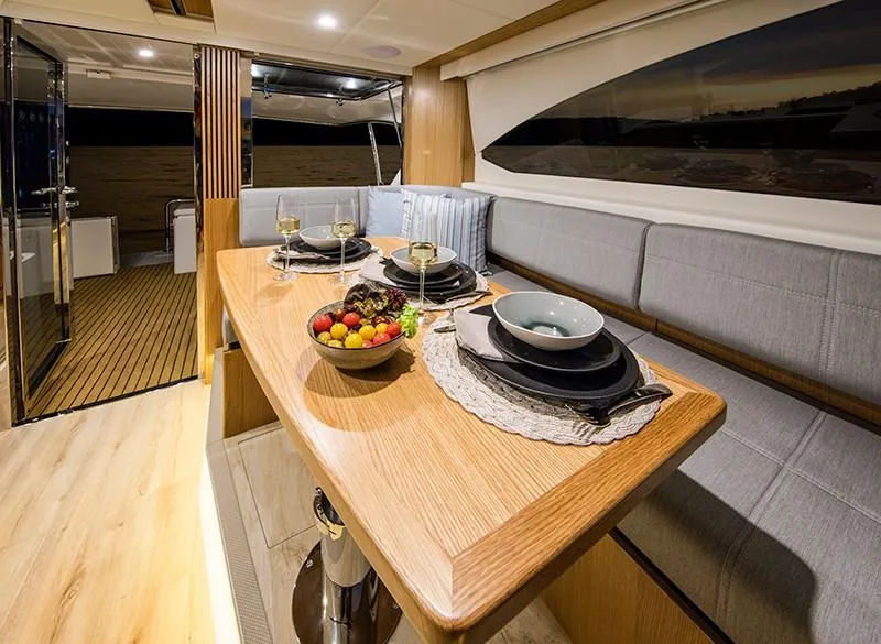 Slide: The Image of Luxurious dining area inside the 2024 Riviera 395 SUV yacht, featuring elegant table settings. - 11